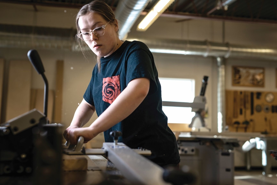 A carpentry student uses a machine inside the SLC workshop